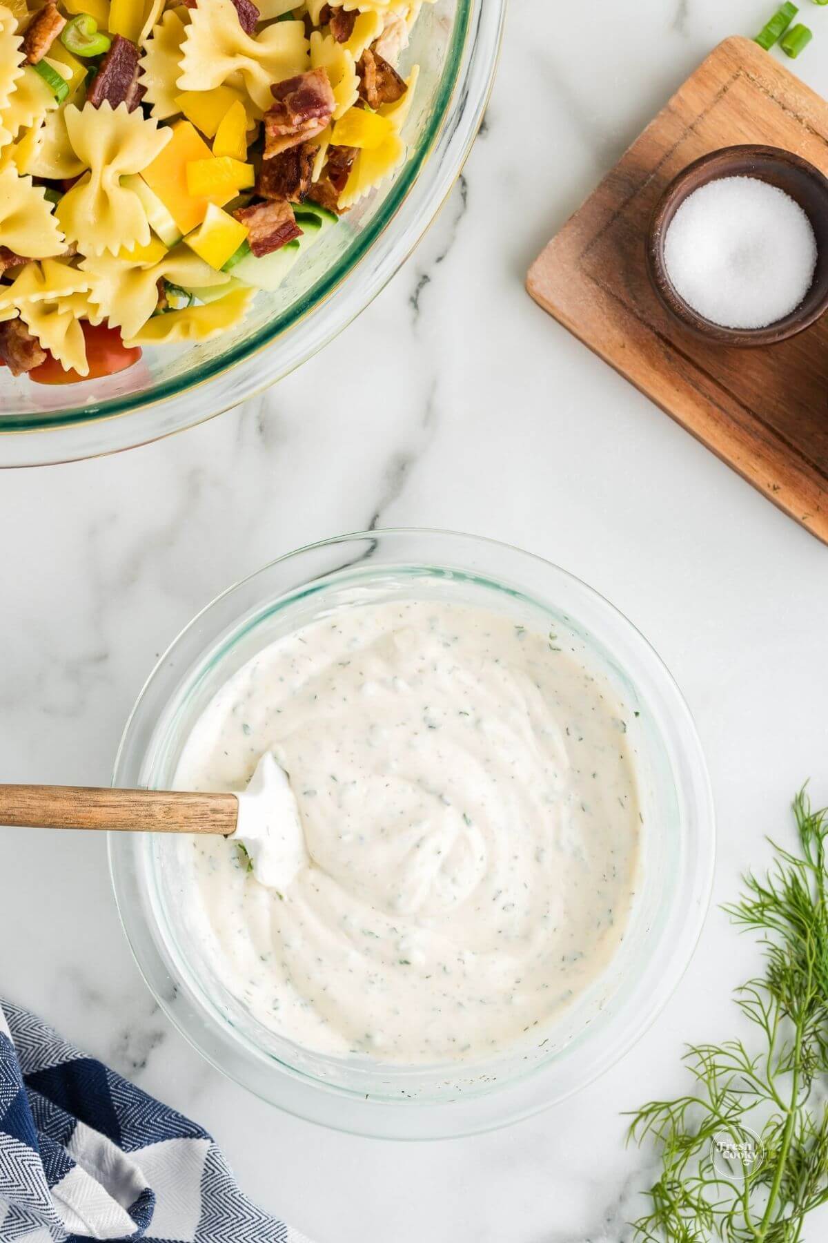 Combing ranch dressing ingredients in small bowl for chicken bacon pasta salad.