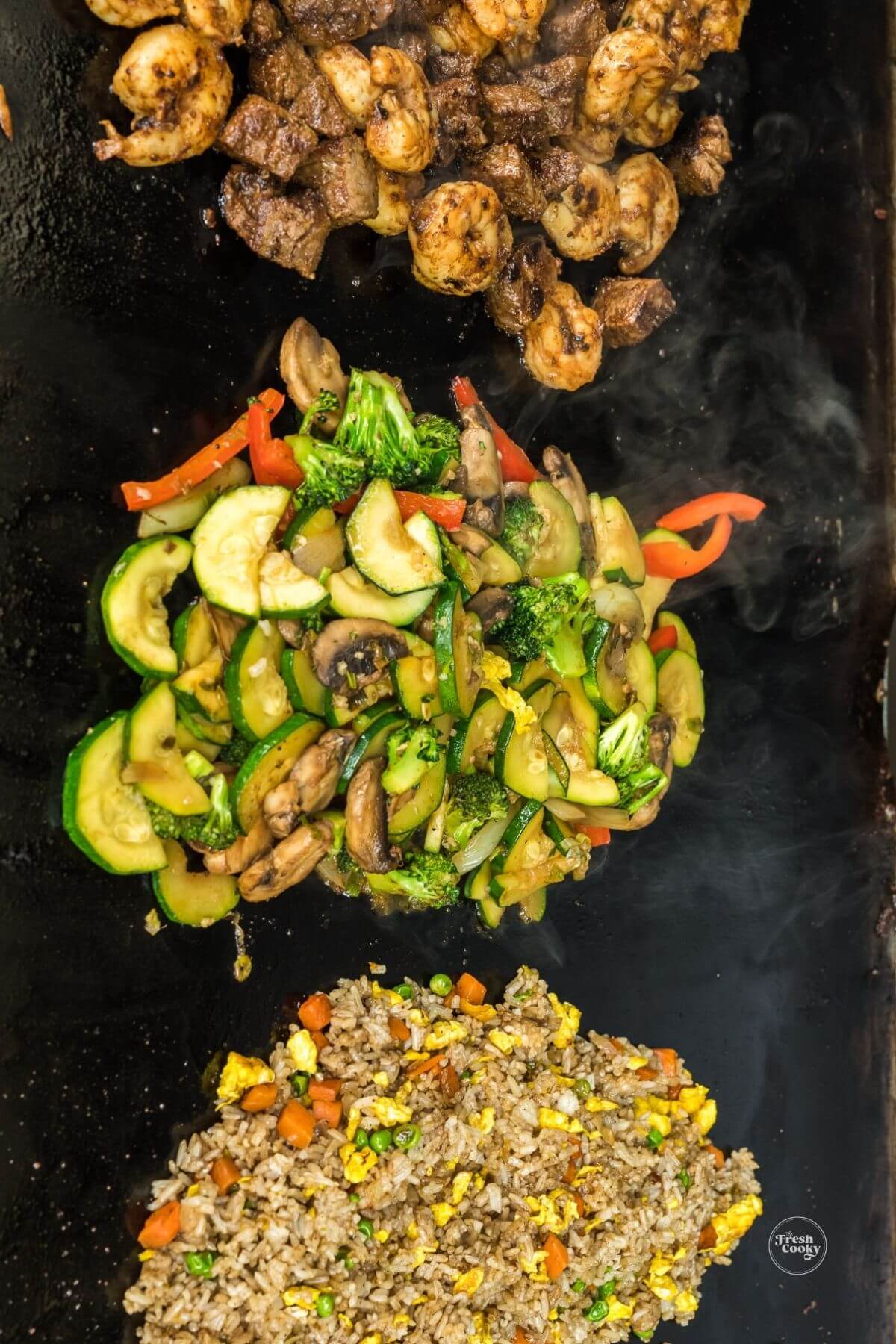 Steak shrimp, veggies and Benihana fried rice on Blackstone grill, ready to serve.