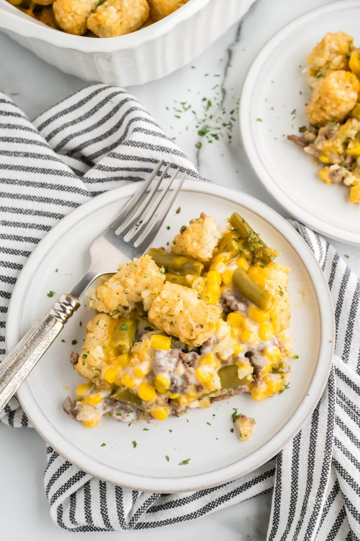Serving of tater tot casserole on plate with fork.