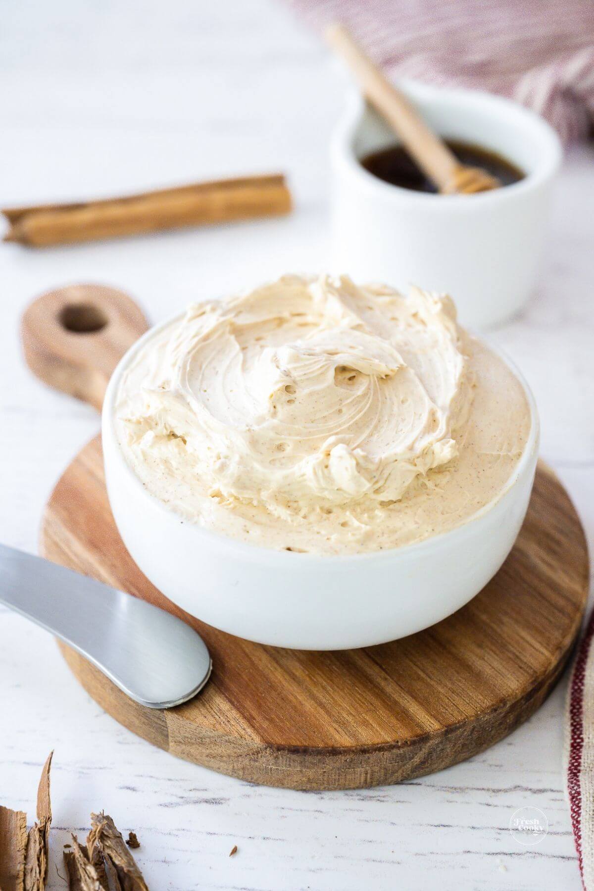 Cinnamon honey butter in a white bowl with a spreader.