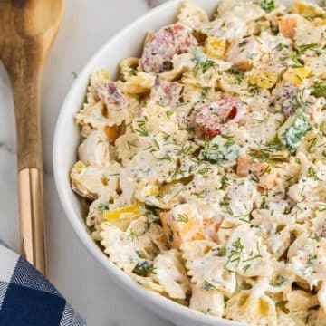 Chicken bacon ranch pasta salad in bowl with wooden spoon.