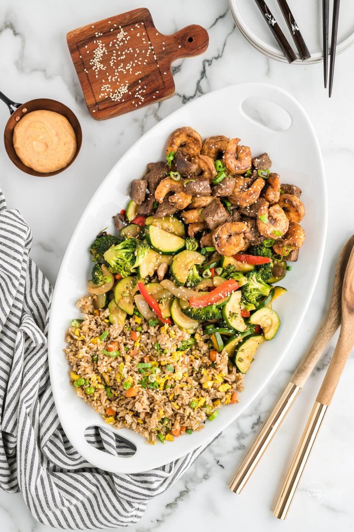 Platter filled with hibachi steak and shrimp, veggies and fried rice with yum yum sauce.