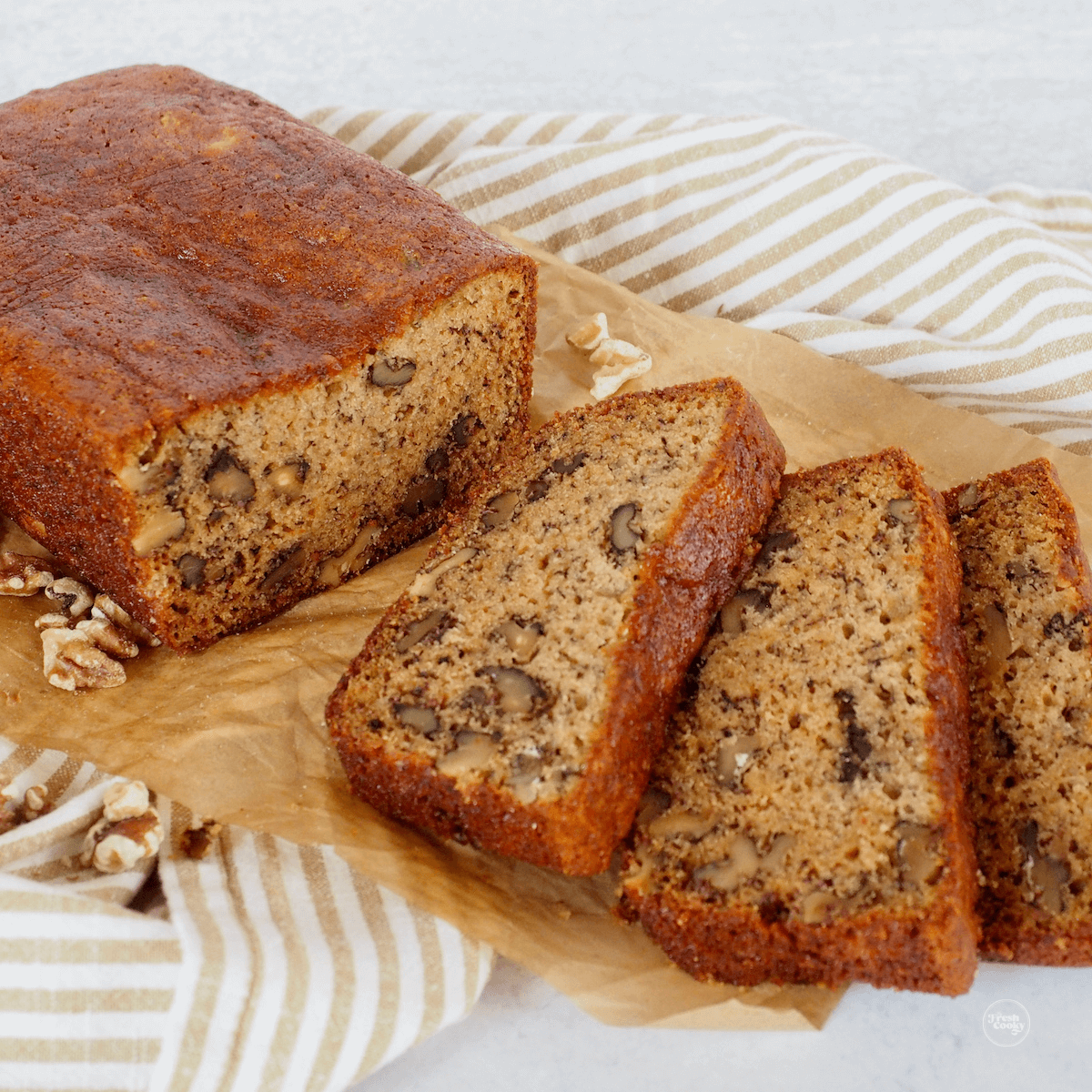 Gluten free banana bread recipes, sliced on parchment for serving.