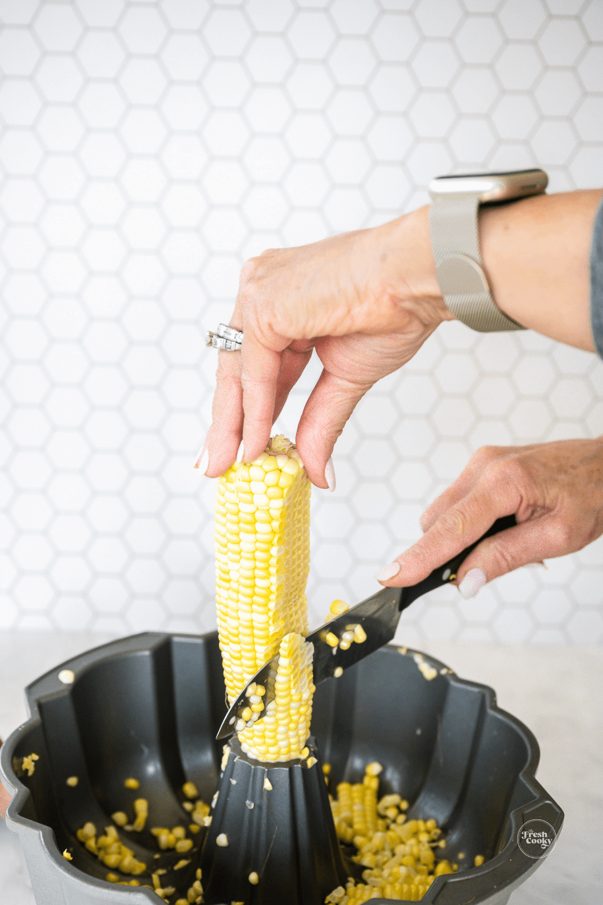 Showing how to cut corn off the cob into a bundt pan for less mess.