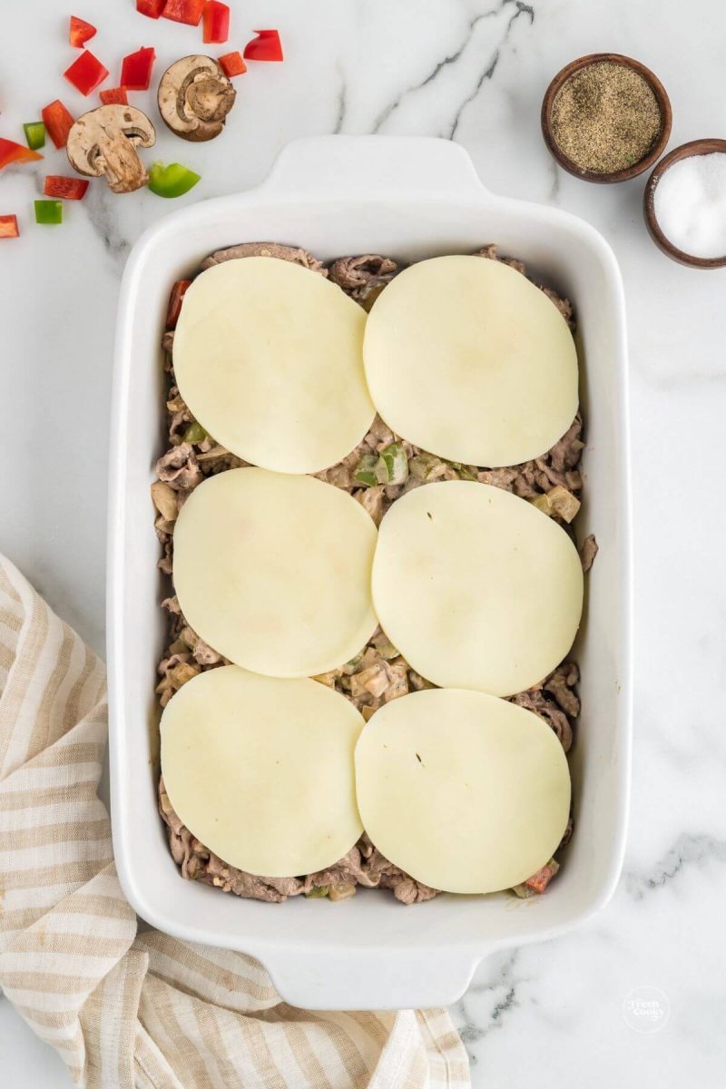Top cheesesteak casserole with provolone cheese. 