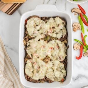 Easy Philly Cheesesteak Casserole in dish with melted provolone cheese on top.