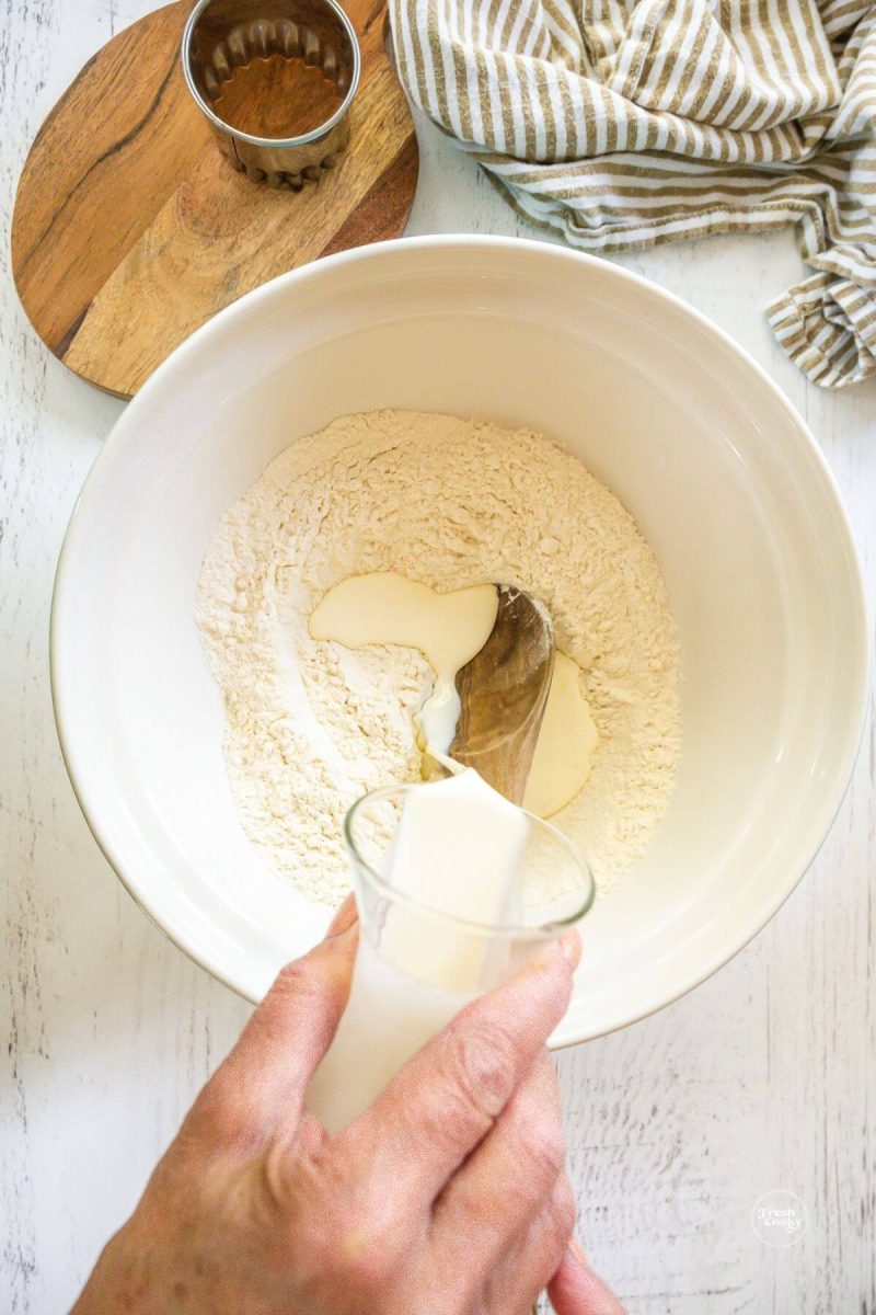 Pouring cream into flour mixture.