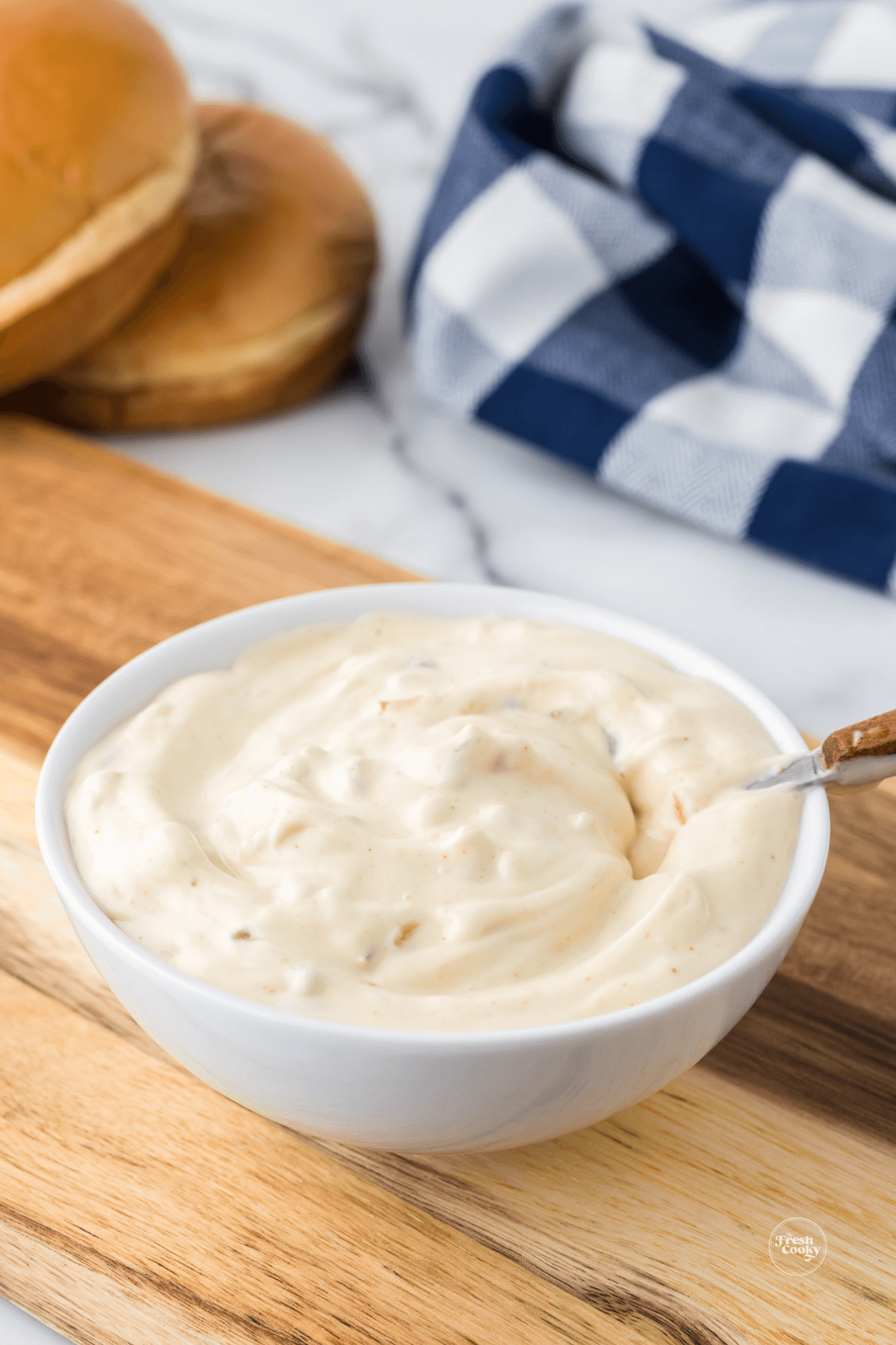Spoon in bowl of creamy smashburger sauce.