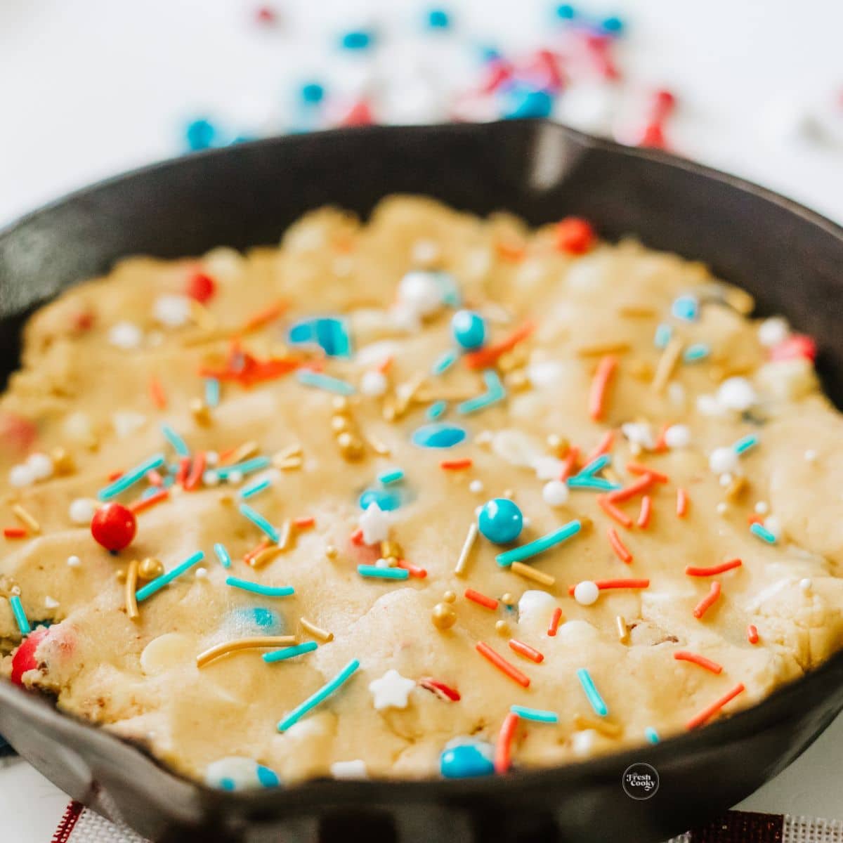 Patriotic cookie dough pressed into skillet and topped with sprinkles. 