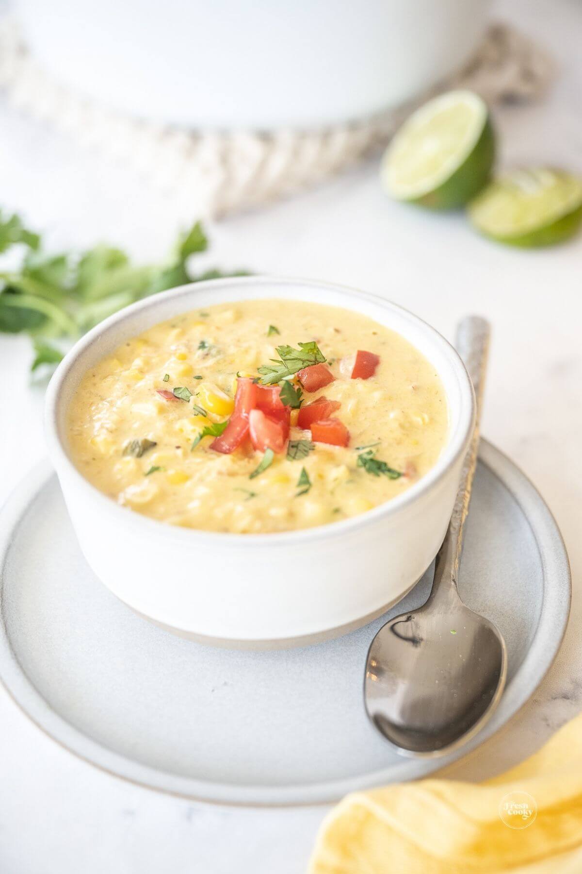 Panera bread corn chowder recipe in bowl with toppings and a spoon, for pinning. 