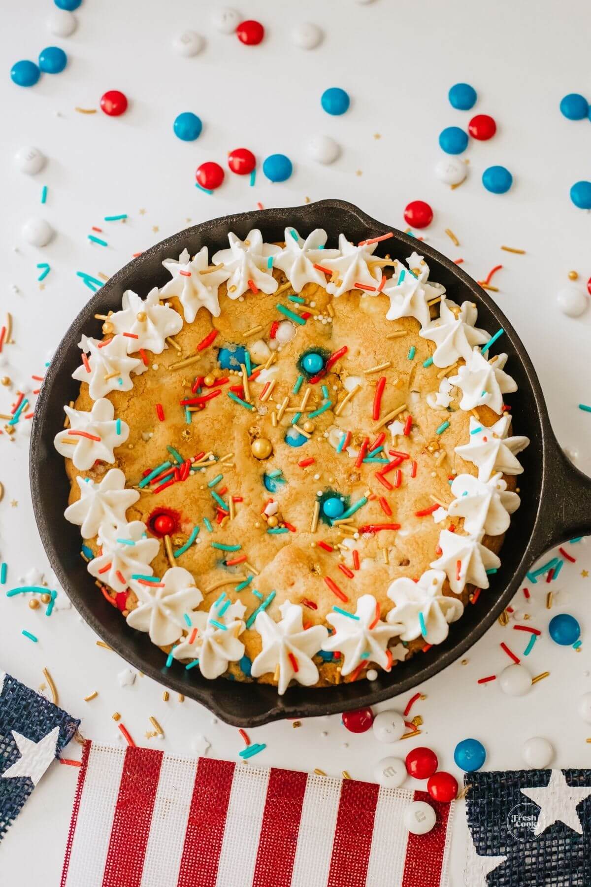 Patriotic cookie skillet cake decorated with frosting and sprinkles.