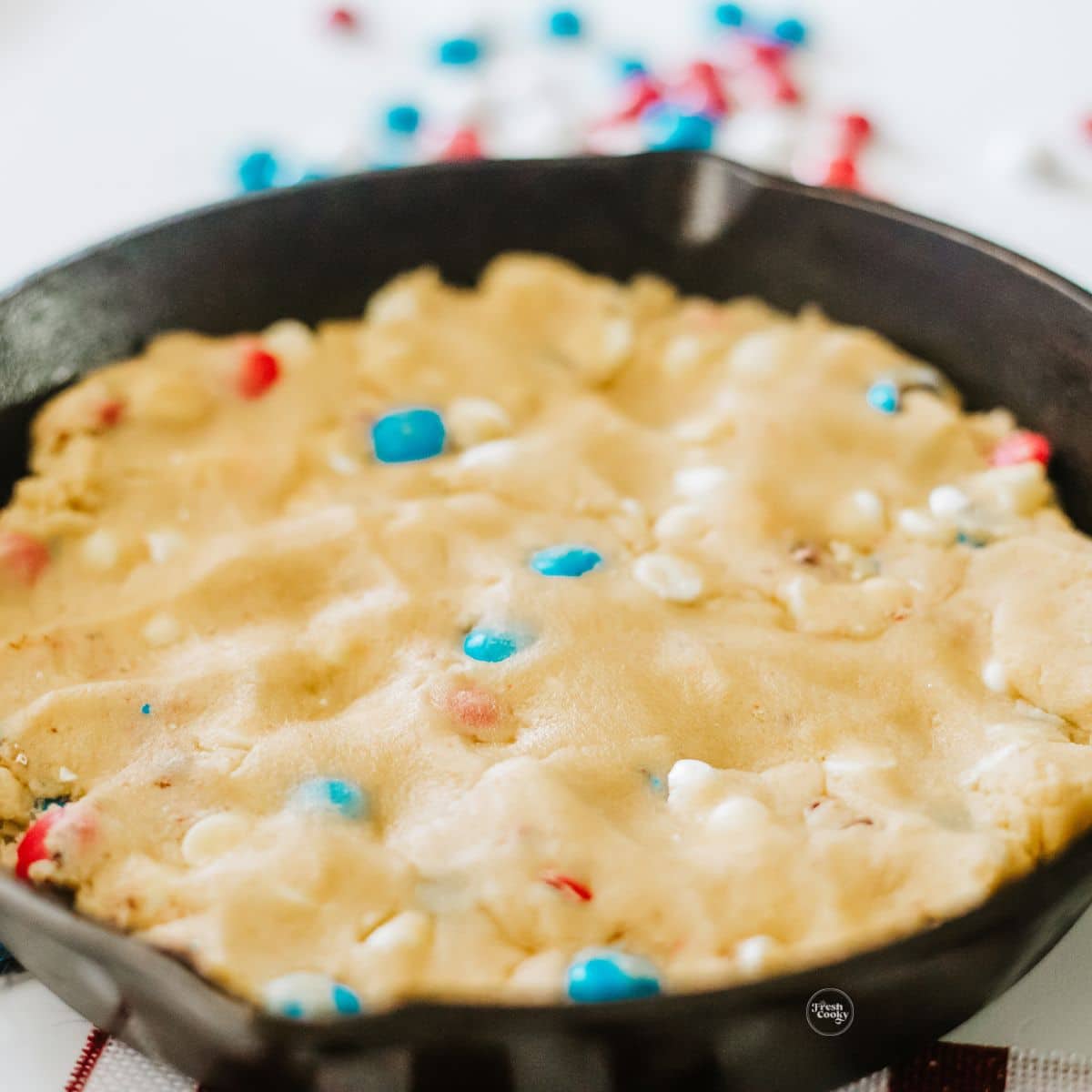 Patriotic cookie dough pressed into cast iron skillet.