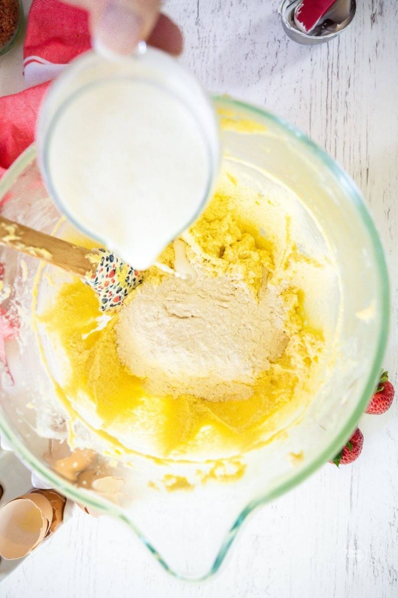 Adding buttermilk to strawberry cake batter.