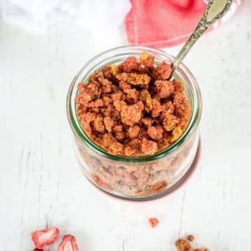 Strawberry crumble topping in jar with spoon.