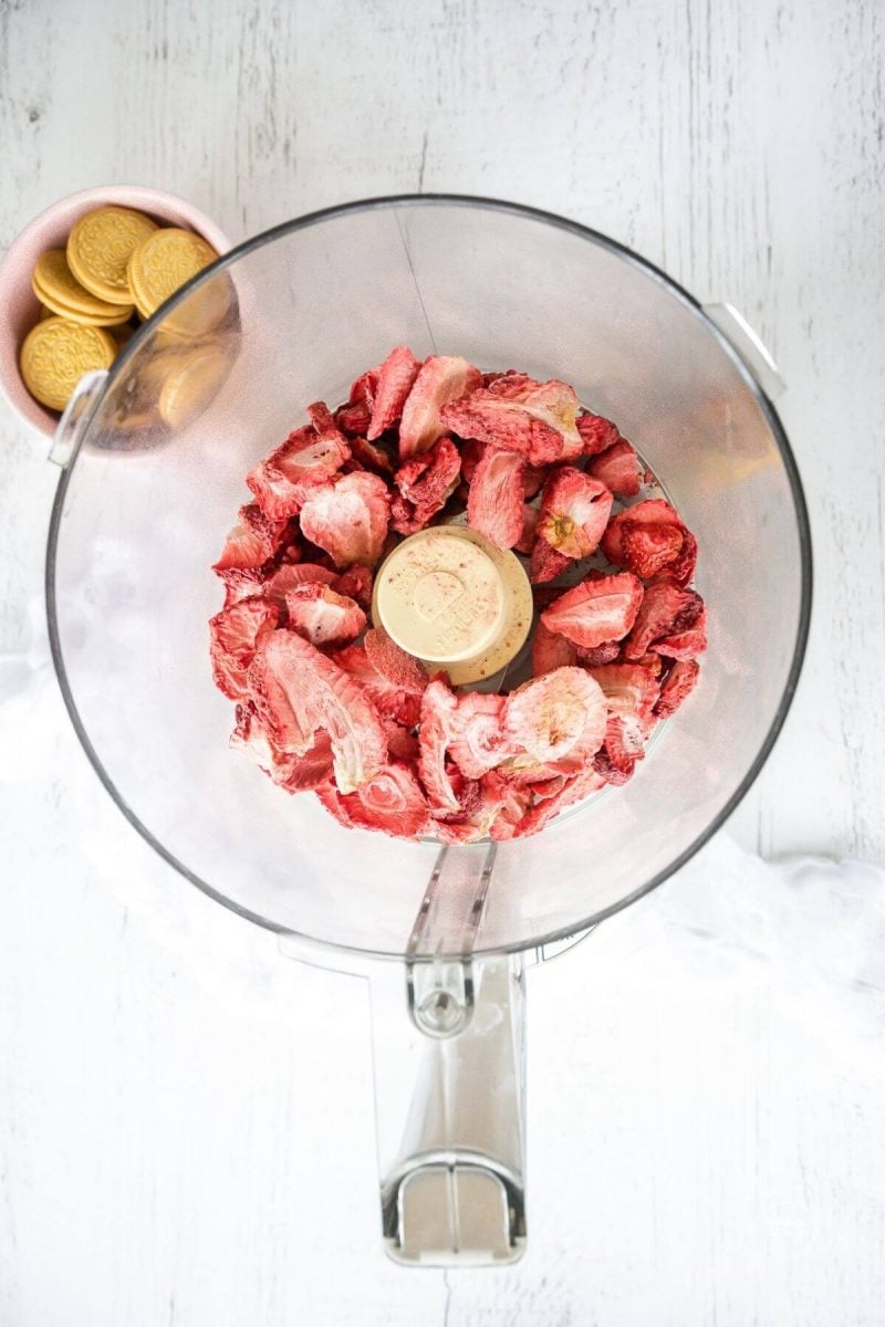 Freeze-dried strawberries in bowl of food processor. 