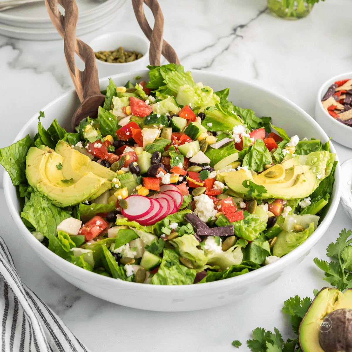 Healthy Mexican salad recipe in large bowl with serving tongs.