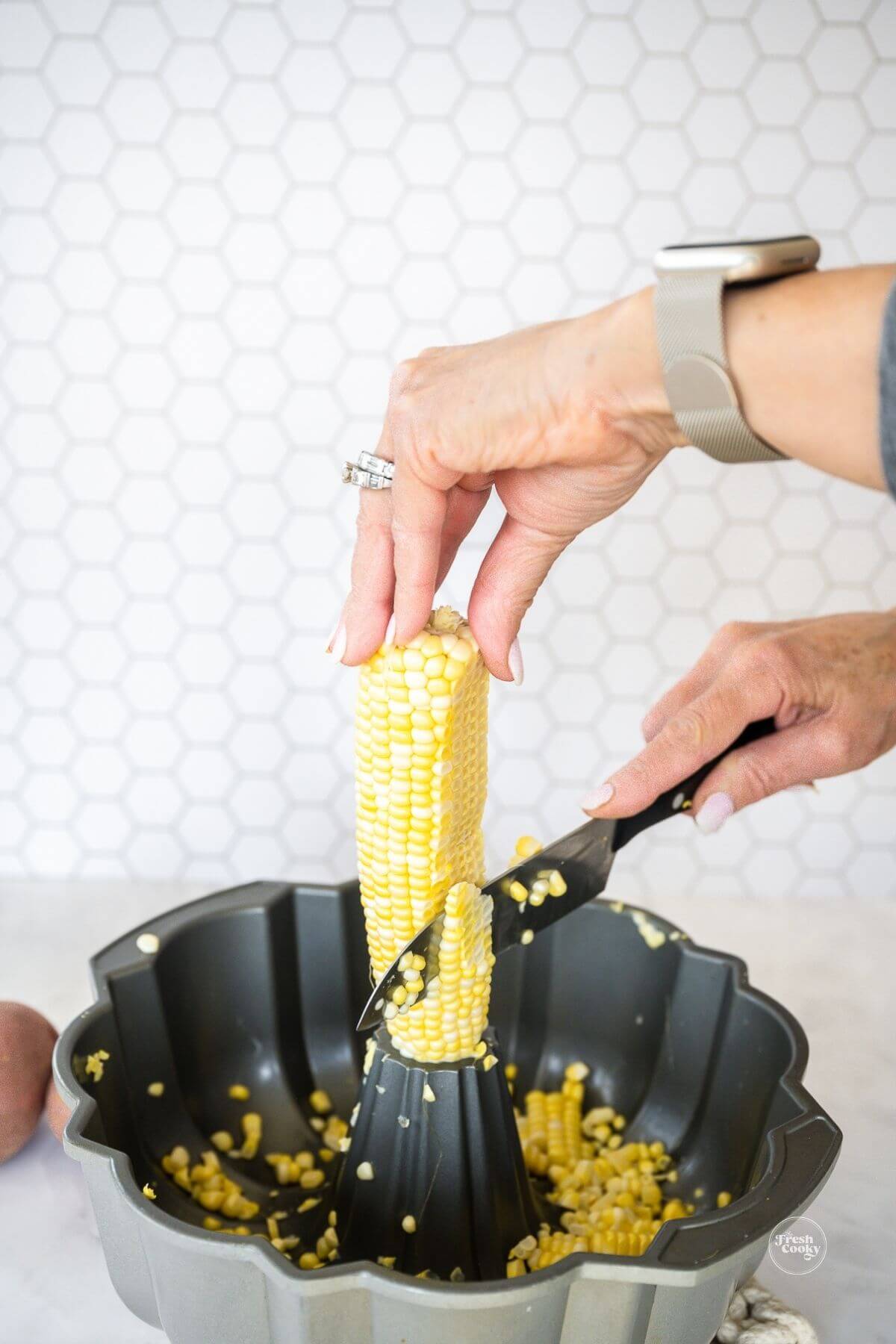 Showing how to cut corn off the cobb without making a big mess.