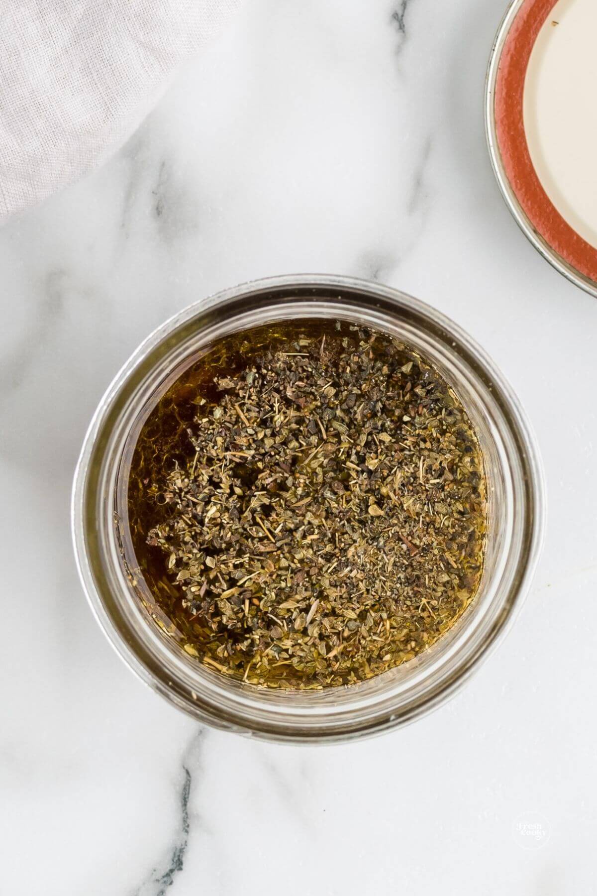 Ingredients placed in jar for Italian vinaigrette recipe.