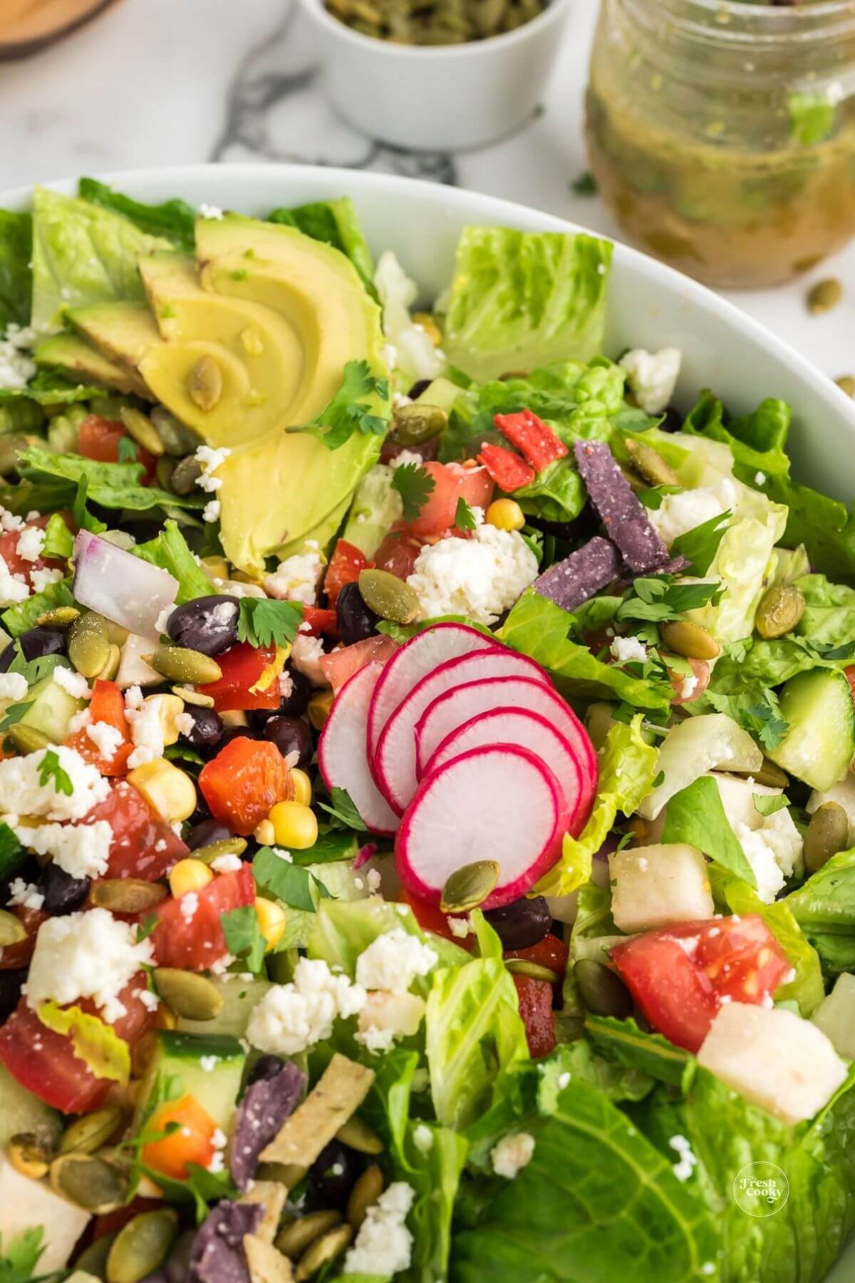 Chopped salad topped with honey lime dressing, close-up.