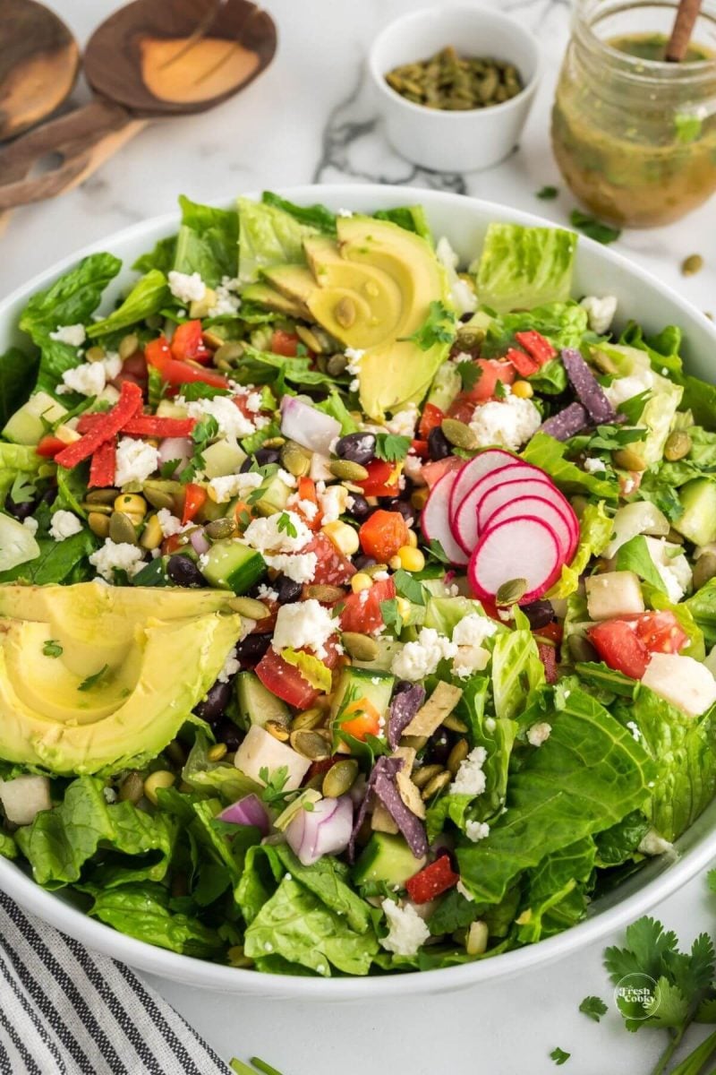 Add avocado, pepitas, radishes, crunchies if desired to Mexican chopped salad.