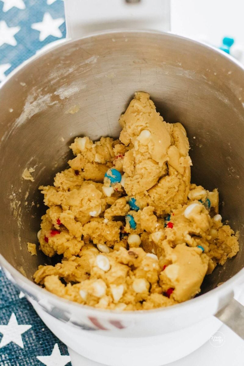 Cookie cake batter with red, white and blue m & ms and white chocolate chips mixed in.