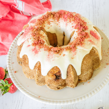 Strawberry Bundt Cake with glaze and topped with strawberry crunch topping.