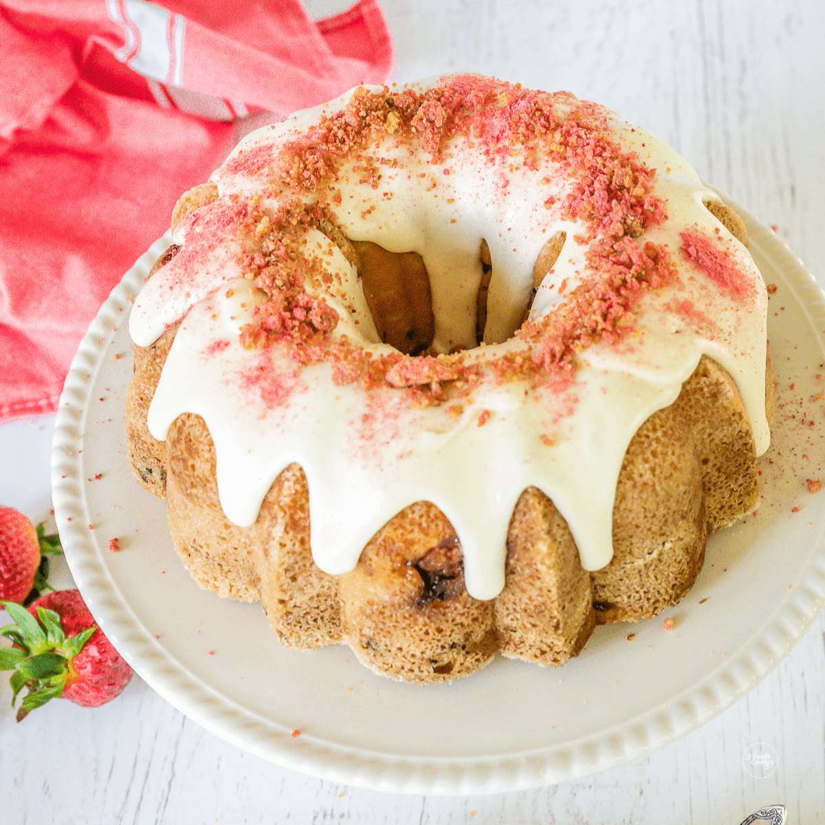 Strawberry Bundt Cake with glaze and topped with strawberry crunch topping. 