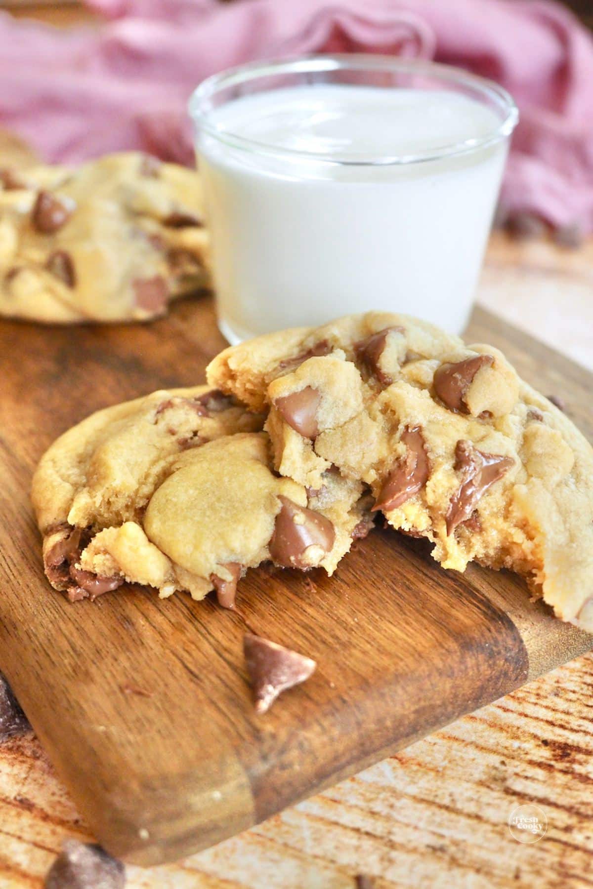 Copycat Crumbl cookie recipe, broken in half with a glass of milk.