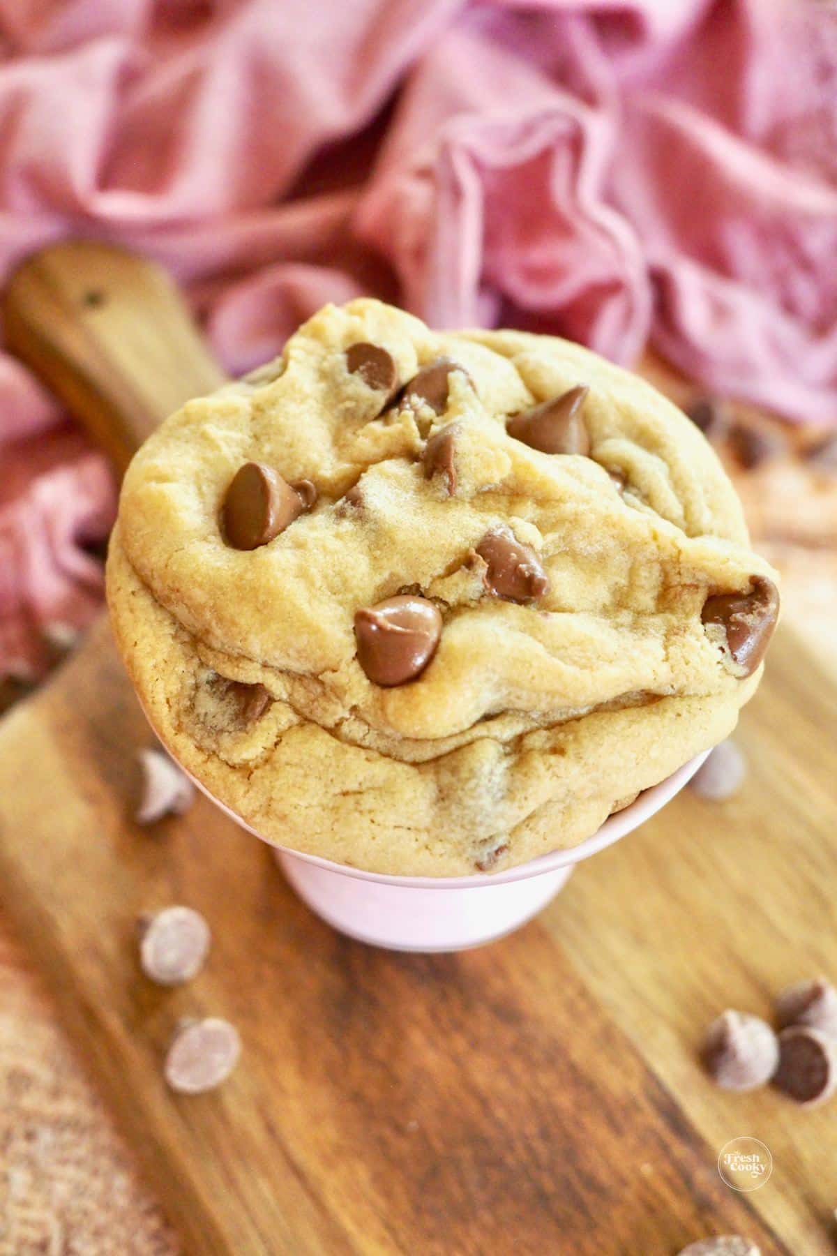 Crumbl cookie with milk chocolate chips on pedestal.