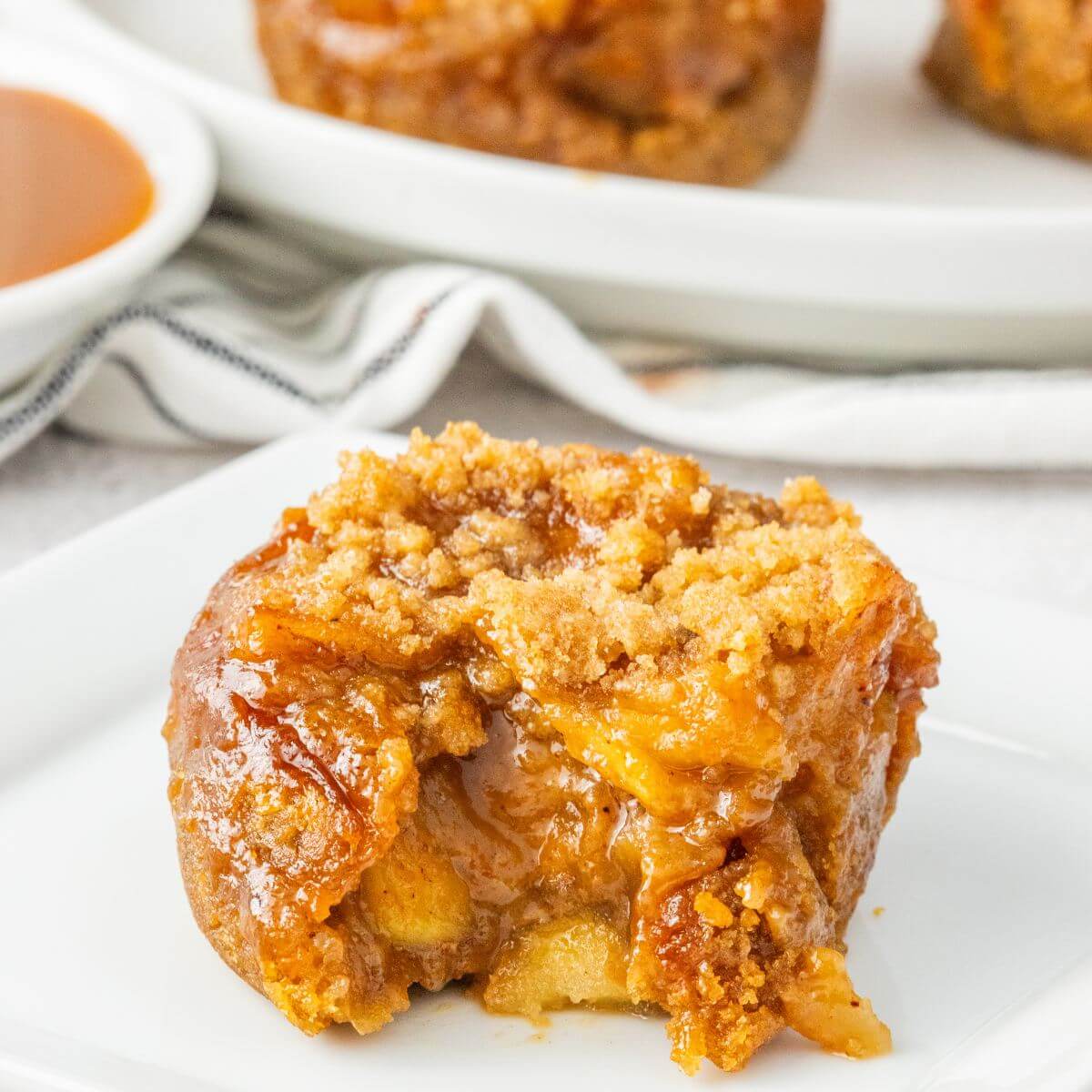 Single mini apple pie recipe with caramel sauce on plate.