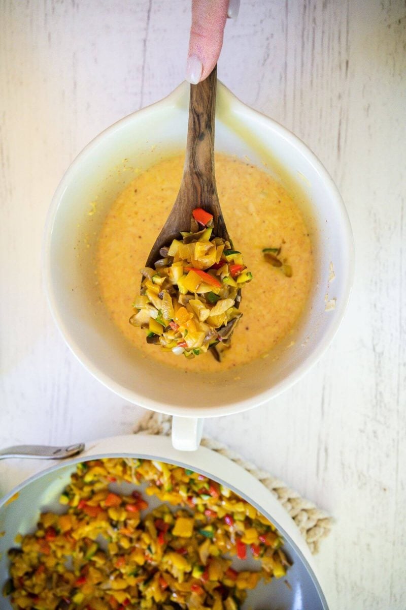 Slowly stir in slightly cooled veggies into egg mixture.