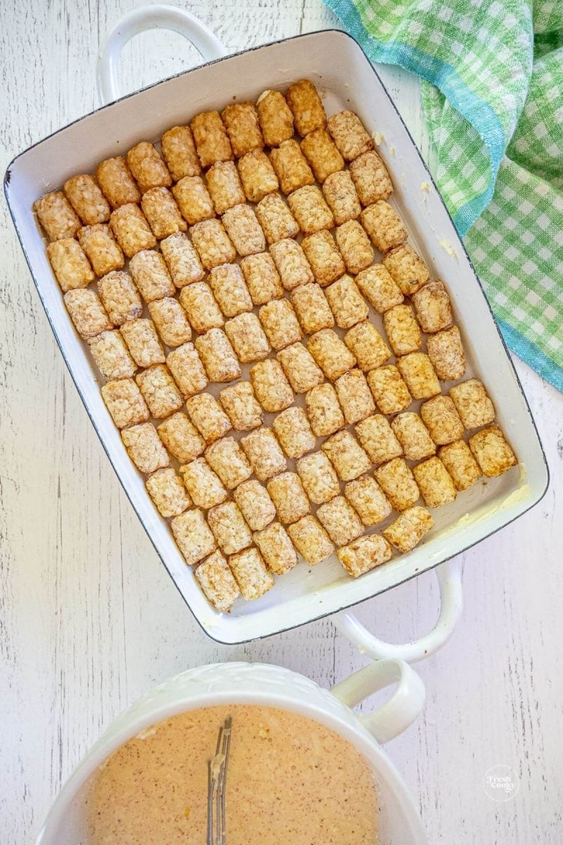 Add tater tots to prepared casserole dish in even layer. 