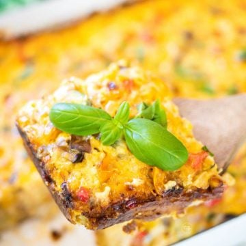 Vegetarian tater tot breakfast casserole with slice on a wooden server.