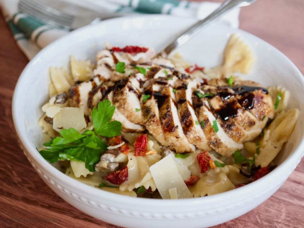 Grilled chicken sliced on creamy pasta drizzled with a balsamic glaze.