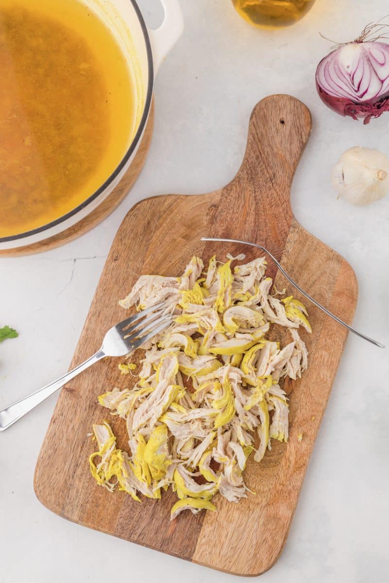 Shredding chicken with two forks.