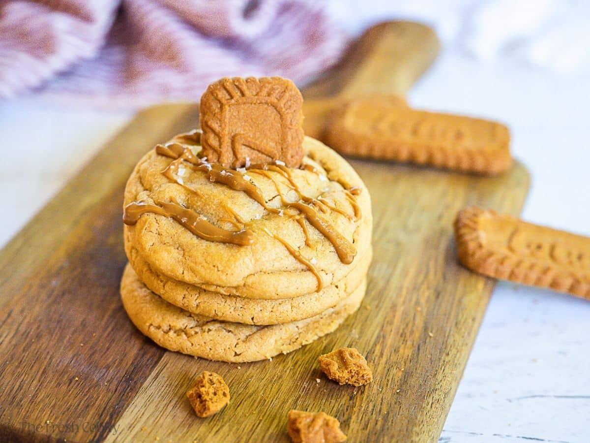Stack of three cookie butter cookies drizzled with frosting and crushed Lotus Biscoff cookies. 