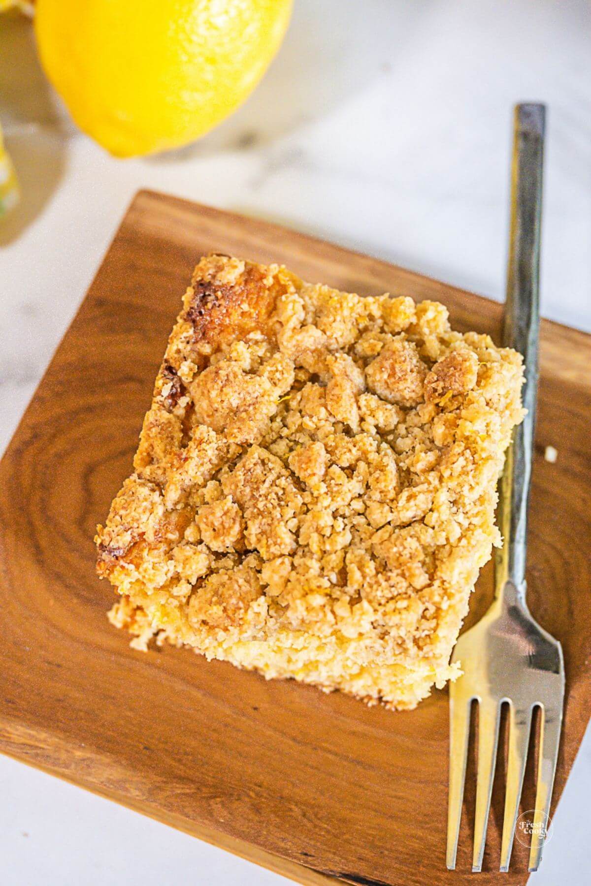 Lemon cake slice on wooden plate.