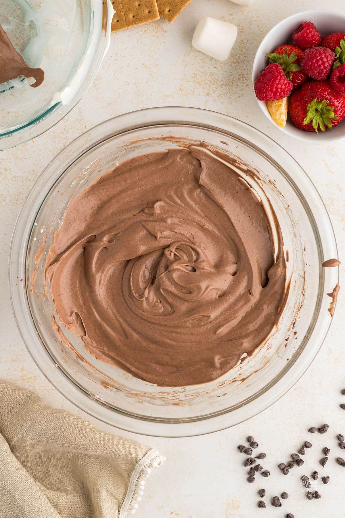 Cream cheese and cocoa mixture combined with whipped cream in a bowl.