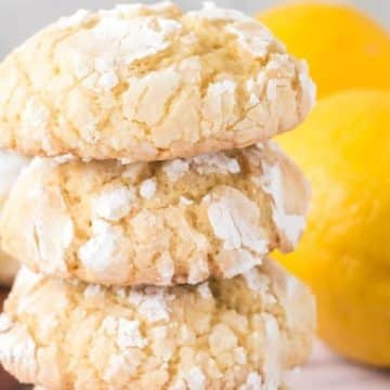 Soft lemon crinkle cookies in a stack of four on the counter.