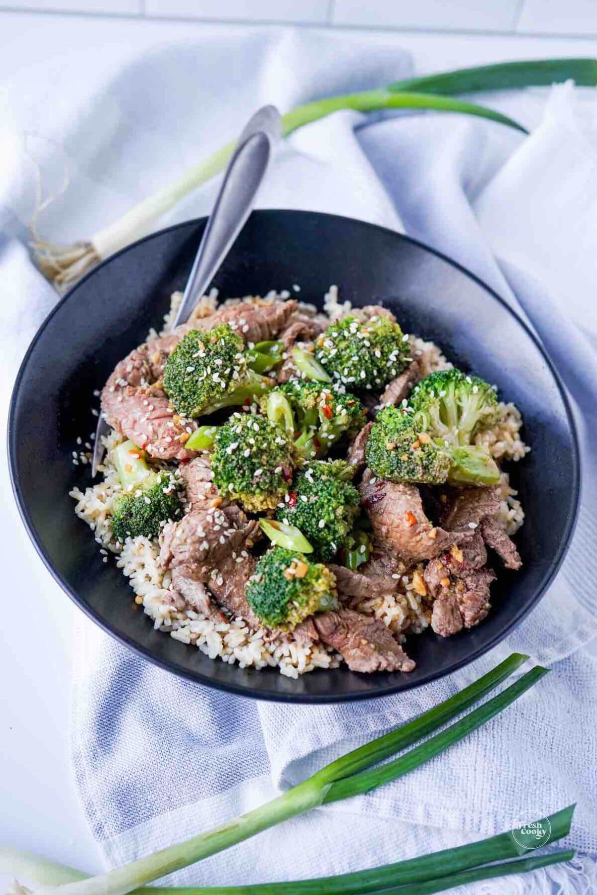 Healthy beef and broccoli stir fry on a bed of brown rice with broccoli.