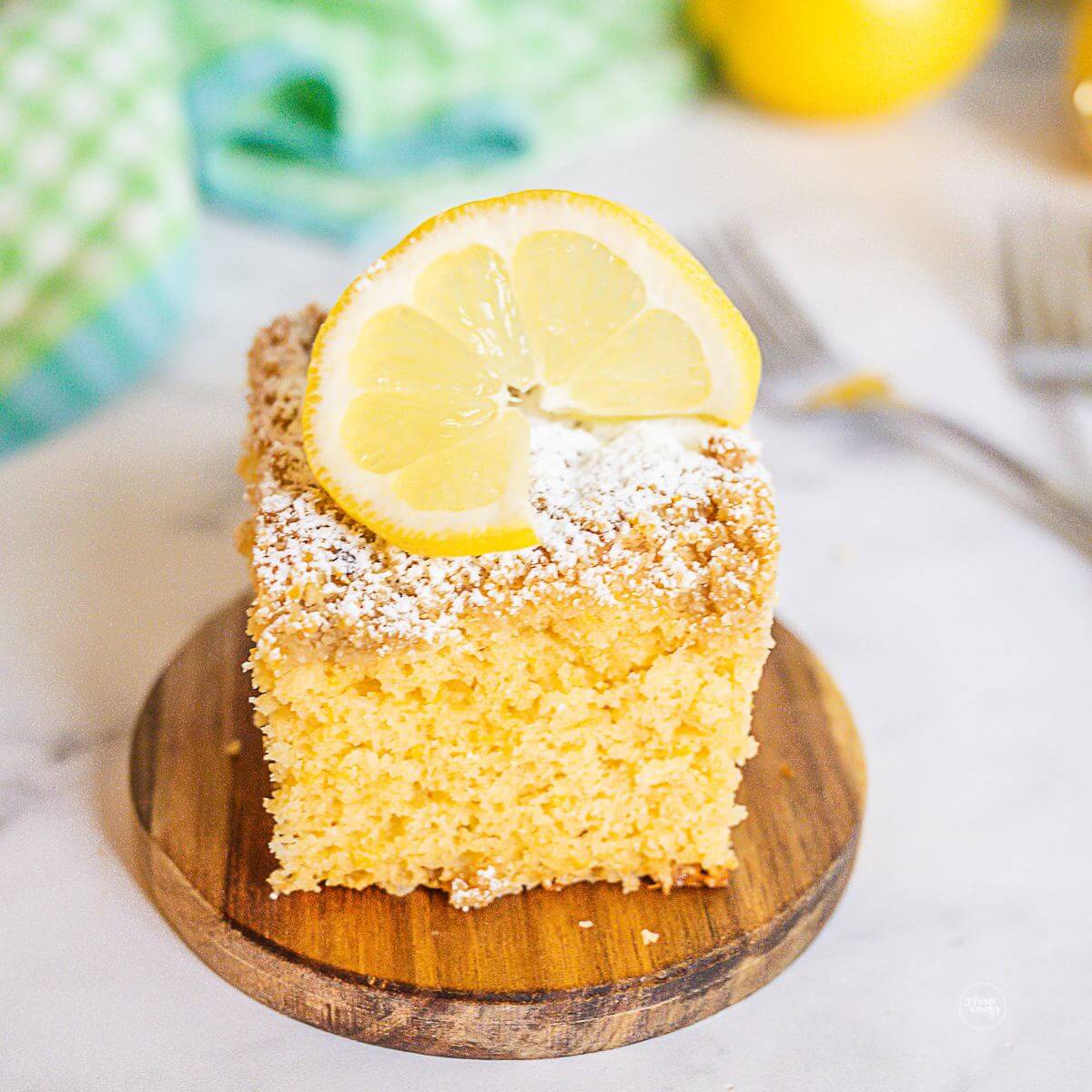 Lemon coffee cake slice on a wooden board.