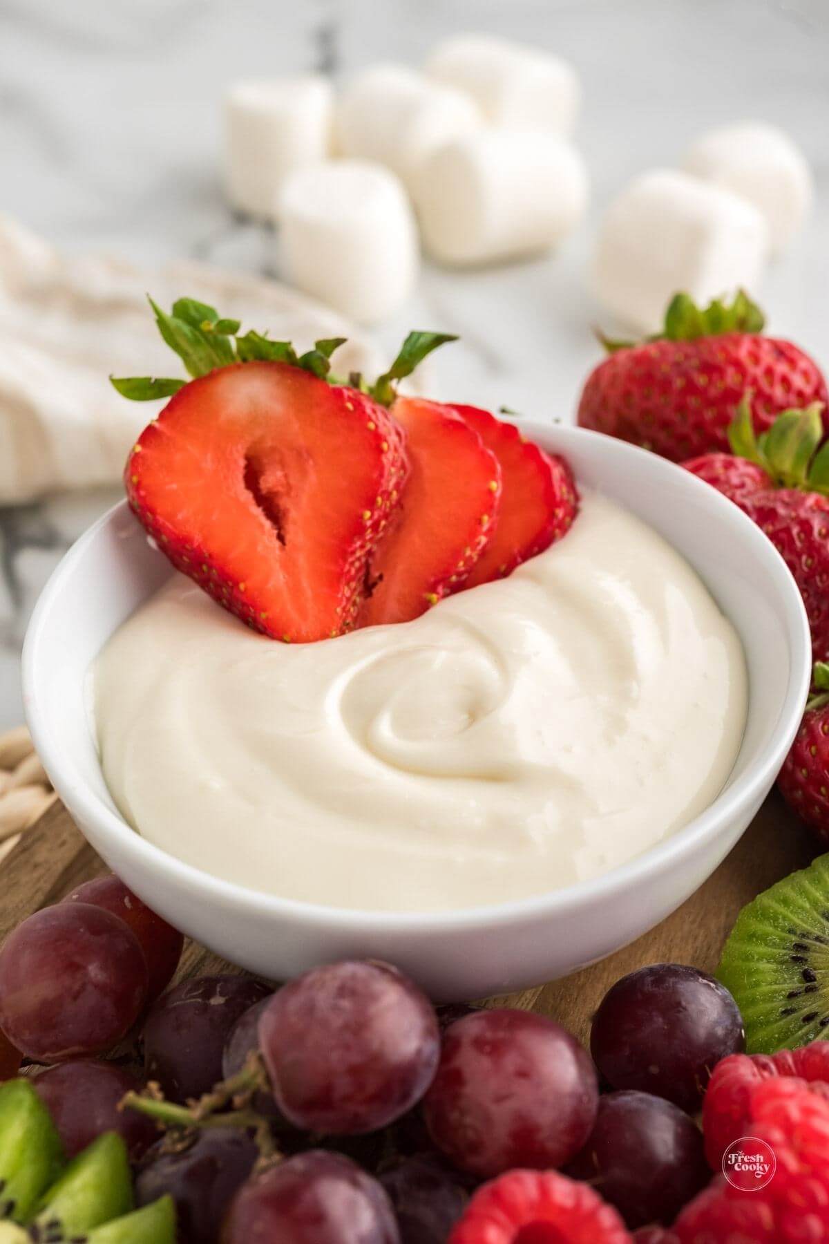 Close-up of marshmallow dip on platter with fruit surrounding.