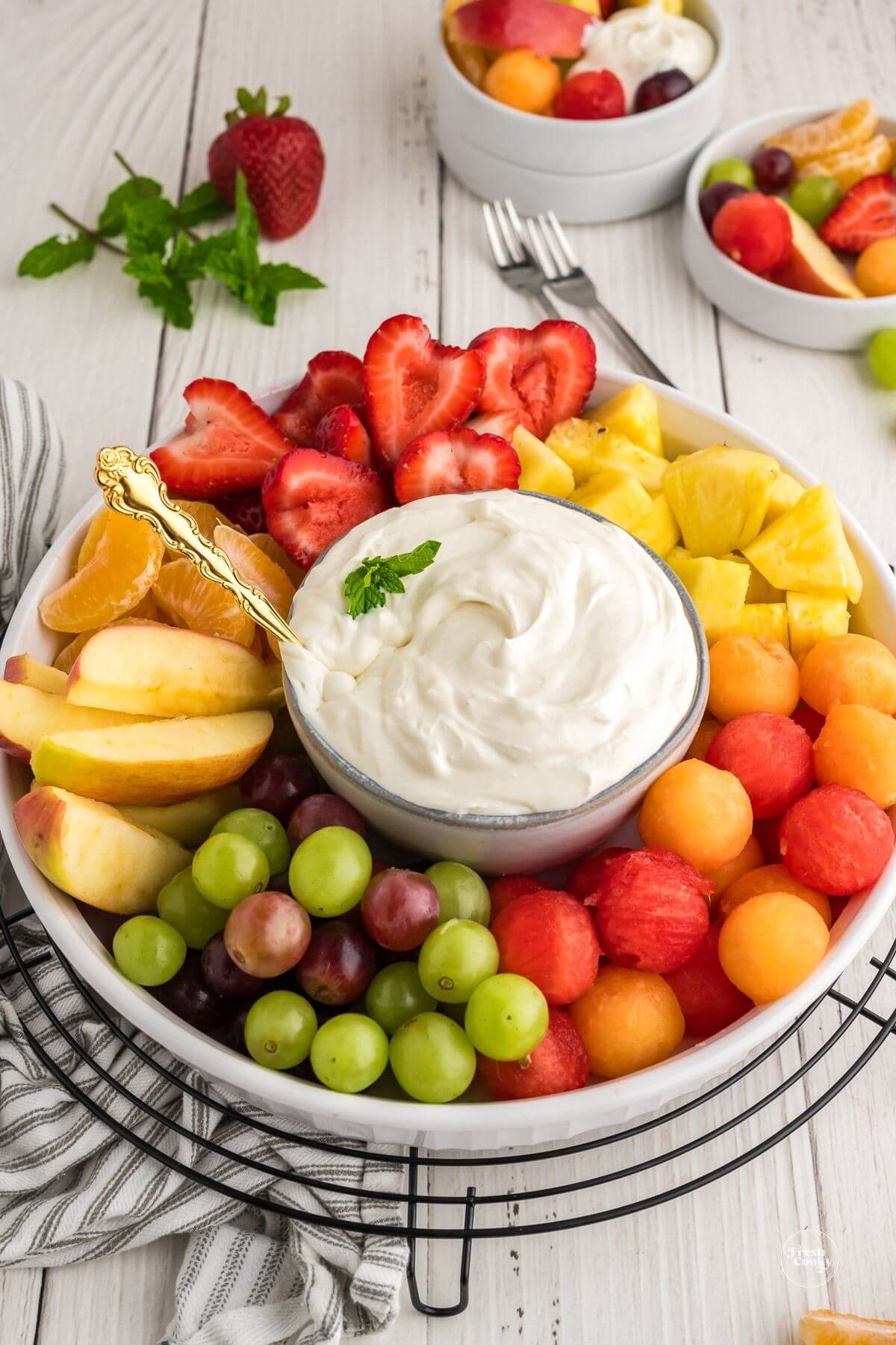 Platter full of fruit surrounding a bowl of easy cream cheese fruit dip.