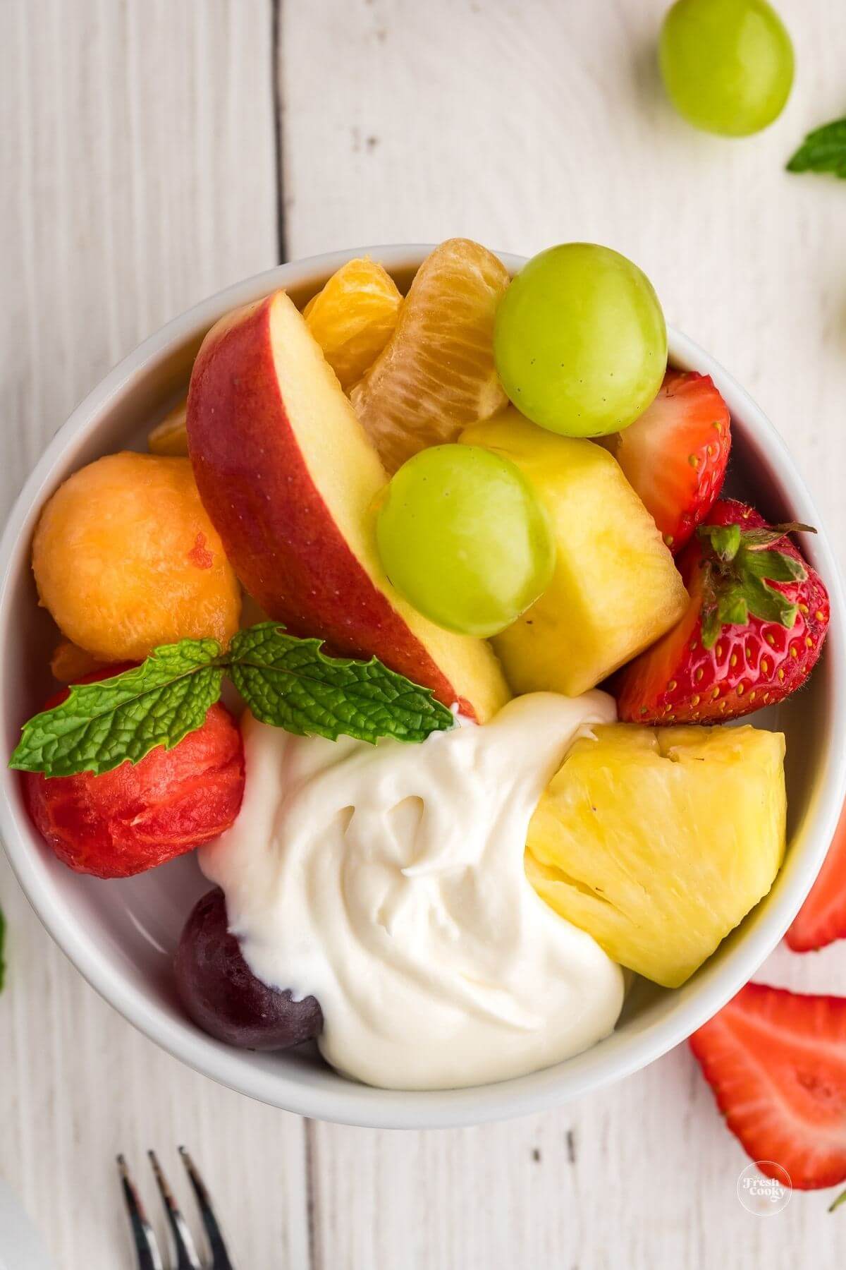 Appetizer plate filled with easy fruit dip and a variety of fruits and melons.