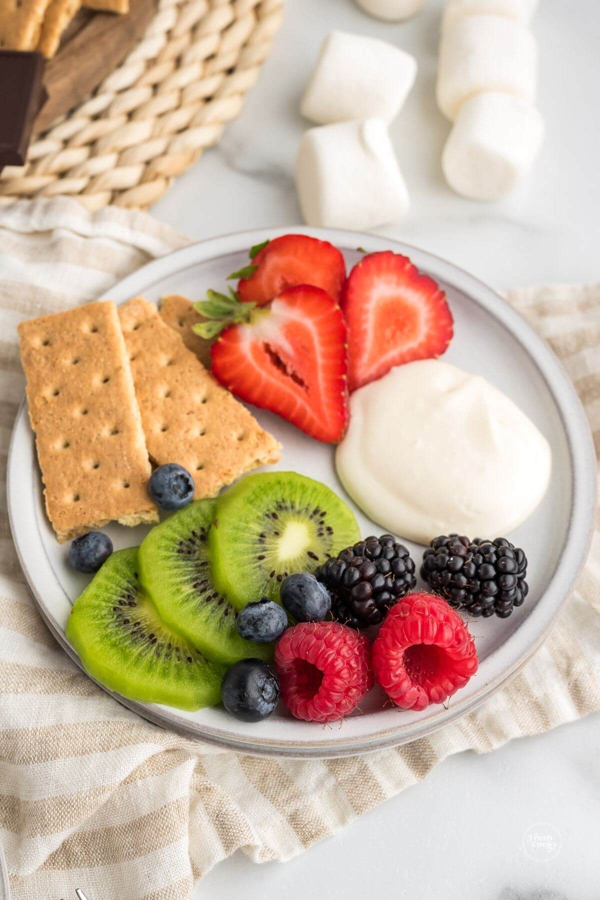 Plateful of fruit and graham crackers with a dollop of marshmallow fruit dip.