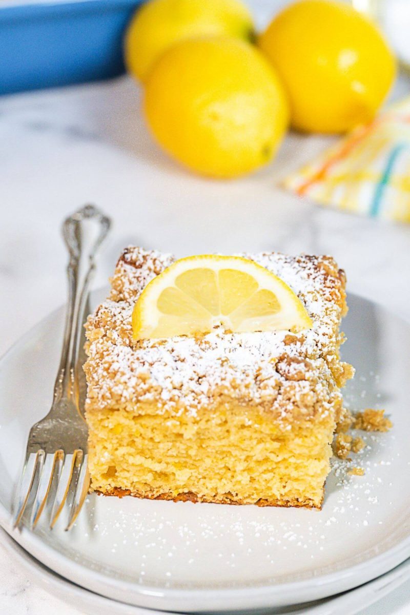 Sugar-free lemon crumb cake slice on plate with fork. 