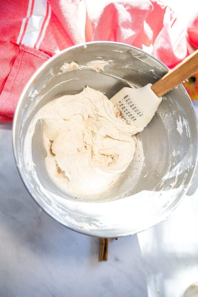 Cream cheese frosting mixed in bowl with spatula.