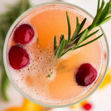 Three cranberries, sprig of rosemary and fizz on top of a Christmas Mimosa.