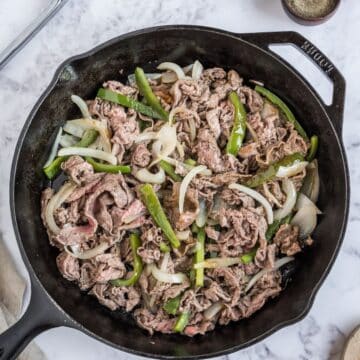 Combine the shaved steak and the veggies in the pan.