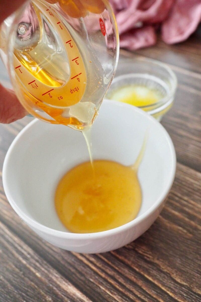 Pouring honey and melted butter into a dish. 